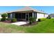 Well-maintained backyard featuring a screened-in porch and neatly landscaped shrubbery at 9593 Se 124Th Loop, Summerfield, FL 34491