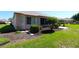 Landscaped backyard with a screened-in porch surrounded by well-manicured shrubs and lawn at 9593 Se 124Th Loop, Summerfield, FL 34491