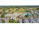 Aerial view of clubhouse, pool, and parking lot in a golf course community at 9593 Se 124Th Loop, Summerfield, FL 34491