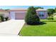 Well-kept home featuring an expansive driveway, tidy landscaping, and a convenient attached garage at 9593 Se 124Th Loop, Summerfield, FL 34491
