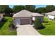 Welcoming home with lush green lawn, manicured shrubbery, and a convenient attached garage at 9593 Se 124Th Loop, Summerfield, FL 34491