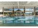 Spacious indoor pool with lane markers, and large windows providing natural light for a refreshing swim experience at 9593 Se 124Th Loop, Summerfield, FL 34491