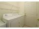 Functional laundry room with white washer and dryer set, wire shelving, and convenient access door at 9593 Se 124Th Loop, Summerfield, FL 34491