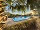 Community pool surrounded by lush greenery and with ample seating around it at 10301 Us Highway 27 # 98, Clermont, FL 34711