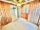 Carpeted sunroom with wood-paneled walls, a ceiling fan and sliding door to the backyard at 10301 Us Highway 27 # 98, Clermont, FL 34711