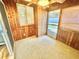 Wood paneled sunroom featuring windows, a door to the yard and carpeted flooring at 10301 Us Highway 27 # 98, Clermont, FL 34711