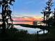 Beautiful sunset view over the lake with a dock and lush greenery at 10301 Us Highway 27 # 98, Clermont, FL 34711