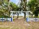 Entrance to Vacation Village featuring a white fence, trees, and a lake view at 10301 Us Highway 27 # 98, Clermont, FL 34711