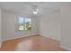 Bright bedroom featuring wood-look floors, a ceiling fan and a large window at 1142 Salido Ave, The Villages, FL 32159