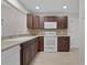 Spacious kitchen with dark wood cabinets, modern appliances, and elegant countertops at 1142 Salido Ave, The Villages, FL 32159