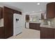 Well-lit kitchen with wooden cabinets, stainless steel refrigerator, and sleek countertops at 1142 Salido Ave, The Villages, FL 32159