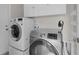 Functional laundry room featuring a modern washer and dryer with storage cabinets at 1142 Salido Ave, The Villages, FL 32159