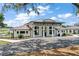 Community clubhouse with beautiful landscaping and modern architecture at 12129 Grand Oak Ln, Oxford, FL 34484