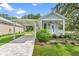 Charming cottage-style home features a covered front porch, carport, and attractive landscaping at 12129 Grand Oak Ln, Oxford, FL 34484