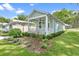 Well-maintained exterior with vibrant green grass, charming landscaping, and light turquoise siding at 12129 Grand Oak Ln, Oxford, FL 34484