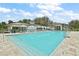Community pool features clear blue water, umbrella-shaded seating, and a spacious deck for residents to enjoy at 12129 Grand Oak Ln, Oxford, FL 34484