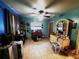 This bedroom features a ceiling fan, a light wood dresser with matching mirror, and turquoise painted walls at 1431 Ne 53Rd St, Ocala, FL 34479