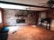 Large room featuring a brick fireplace, wood-look flooring, and a ceiling fan at 1431 Ne 53Rd St, Ocala, FL 34479
