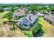 Aerial view of the property showcasing the screened-in pool, fenced backyard, and surrounding landscaping at 16538 Rockwell Heights Ln, Clermont, FL 34711