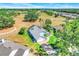 Enjoy an aerial view of this property featuring a manicured lawn, paved driveway, and lush surrounding landscape at 16538 Rockwell Heights Ln, Clermont, FL 34711