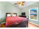 A nicely appointed bedroom with a ceiling fan and backyard views at 16538 Rockwell Heights Ln, Clermont, FL 34711