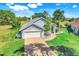 Charming single-story home with a brick driveway, two-car garage, and well-manicured lawn at 16538 Rockwell Heights Ln, Clermont, FL 34711