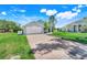 Well-maintained home featuring a brick driveway, 2-car garage, and a lush, green lawn at 16538 Rockwell Heights Ln, Clermont, FL 34711