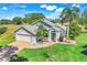 Charming home with manicured lawn, brick driveway, 2 car garage, and inviting front porch at 16538 Rockwell Heights Ln, Clermont, FL 34711