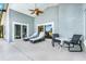 Relaxing covered patio with ceiling fan, stylish lounge chairs, and an outdoor dining set at 16538 Rockwell Heights Ln, Clermont, FL 34711