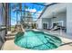 This screened pool area is perfect for relaxation, with a waterfall and lounge seating at 16538 Rockwell Heights Ln, Clermont, FL 34711