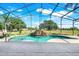 The screened pool area boasts a waterfall feature and a lush outdoor view at 16538 Rockwell Heights Ln, Clermont, FL 34711