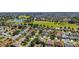 This aerial shot features a home in a neighborhood near a golf course and water at 1743 Landrum Ln, The Villages, FL 32162
