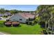 Aerial shot of backyard featuring mature landscaping, a screened lanai, and lush lawn at 1743 Landrum Ln, The Villages, FL 32162