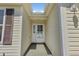 A covered front entry with a glass-paned front door and neutral siding at 1743 Landrum Ln, The Villages, FL 32162