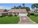 Charming home with a two-car garage, decorative driveway, and beautiful landscaping at 1743 Landrum Ln, The Villages, FL 32162
