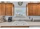 The double sink with window view and wooden cabinets at 1743 Landrum Ln, The Villages, FL 32162