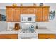 A kitchen stovetop with overhead microwave and wooden cabinetry at 1743 Landrum Ln, The Villages, FL 32162