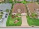 Aerial view of the home featuring well-manicured lawn, landscaping, driveway compass and nearby car at 17930 Se 87Th Bourne Ave, The Villages, FL 32162