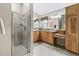Bright bathroom with a glass shower, double vanity, and wood cabinetry at 17930 Se 87Th Bourne Ave, The Villages, FL 32162