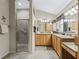A well-lit bathroom featuring a glass shower and dual vanity at 17930 Se 87Th Bourne Ave, The Villages, FL 32162
