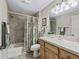 Bathroom with a shower-tub combo and a vanity with a sink and mirror at 17930 Se 87Th Bourne Ave, The Villages, FL 32162