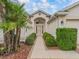 Welcoming front entrance featuring a charming walkway framed by lush greenery and a decorative door at 17930 Se 87Th Bourne Ave, The Villages, FL 32162