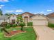 Charming single-story home featuring a well-manicured lawn and inviting facade with a two car garage at 17930 Se 87Th Bourne Ave, The Villages, FL 32162