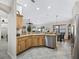 Kitchen with stainless steel dishwasher, sink, and wooden cabinets at 17930 Se 87Th Bourne Ave, The Villages, FL 32162