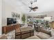 Cozy living room featuring large windows, an elegant ceiling fan, and a beautiful view of the backyard patio at 17930 Se 87Th Bourne Ave, The Villages, FL 32162