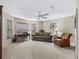 Inviting living room with comfortable seating, carpet flooring, and natural light at 17930 Se 87Th Bourne Ave, The Villages, FL 32162