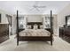 Well-lit main bedroom with four-poster bed, ceiling fan, and soft carpeting at 17930 Se 87Th Bourne Ave, The Villages, FL 32162