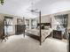 Primary bedroom with carpet, ceiling fan, a four-poster bed, and side tables at 17930 Se 87Th Bourne Ave, The Villages, FL 32162