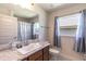 Bright bathroom featuring a granite countertop vanity and shower-tub combo at 1922 Angel Fish Loop, Leesburg, FL 34748