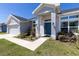Inviting entryway of the house with a blue front door, manicured landscaping, and a clean walkway at 1922 Angel Fish Loop, Leesburg, FL 34748